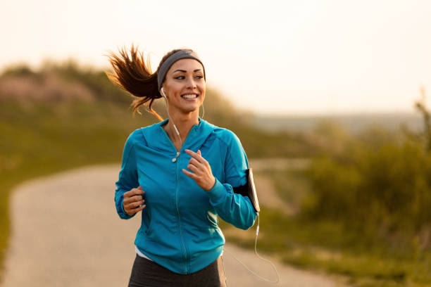 Dedicated athletic woman running in nature and dawn.